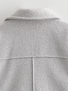 Detail view of the gray faux shearling texture and yoke stitching on a women's short jacket