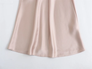 Gros plan détaillé sur la texture du satin champagne et les coutures de qualité de la robe