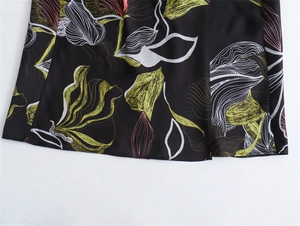 Close-up of lightweight satin midi dress fabric with abstract green and pink floral prints