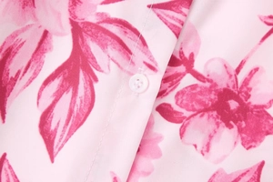 Nahaufnahme des Hemdes mit Blumendruck, magentafarbenen Blüten und weißen Knöpfen im Detail