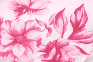 Nahaufnahme des rosa Blumendruck-Stoffes mit einem transparenten weißen Knopfdetail