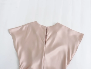 Détail de la robe en satin montrant le tissu rose champagne et la fermeture éclair invisible