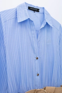 Détail de la robe chemise à rayures bleues avec ceinture en jute et boutons marron