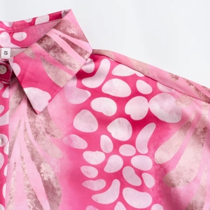 Close-up of pink floral shirt collar with silky texture and detailed abstract patterns