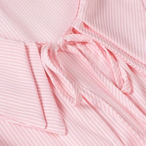 Detail of pink and white striped shirt featuring a stylish bow tie neckline and collar
