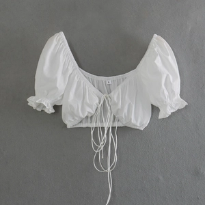 Detail of white cropped top with drawstring chest, puff sleeves and ruffled cuffs