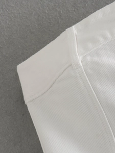 Dettaglio della vita in twill bianco con passanti per cintura rinforzati e cuciture fini