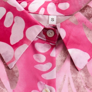 Detail of floral print shirt collar with white buttons and smooth fabric texture