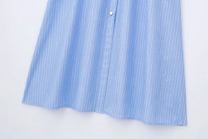 Vue détaillée du tissu à rayures bleues et blanches avec un bouton doré haut de gamme