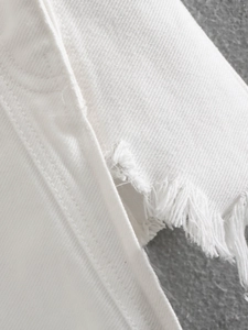 Dettaglio del tessuto denim bianco con orlo a taglio vivo e trama in twill visibile