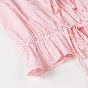 Close-up of pink white striped fabric with pleated details and side tie design