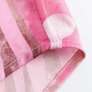 Detail of pink and brown striped fabric with white polka dots and fine stitching