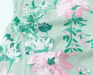 Detail of floral print on light green linen blend fabric with pink and white flowers