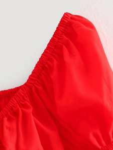 Close-up of the elastic smocked cuffs on a red flare sleeve summer top for women