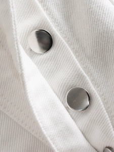 Dettaglio macro di due bottoni in metallo argentato su tessuto in twill bianco premium
