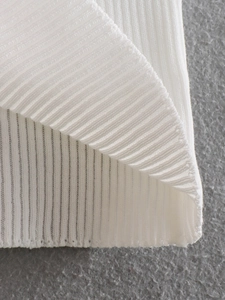 Detailed close-up of premium white ribbed knit fabric showing vertical texture and elasticity