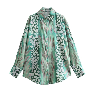Detail of mint green floral blouse showing buttoned collar and abstract print texture