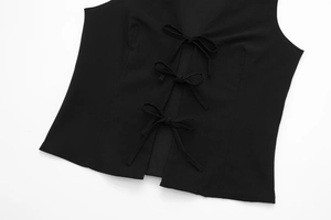 Détail du haut extensible noir avec trois nœuds papillon et coutures princesse élégantes