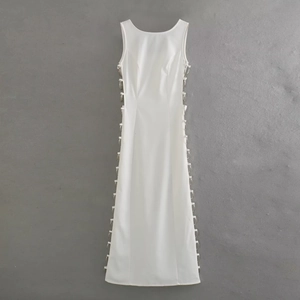 Detail of white sleeveless dress showing side cutouts with silver metal ring ornaments