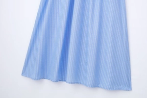 Détail de l'ourlet d'une robe rayée bleu clair avec coutures soignées et coton