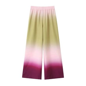 Detail of high-waisted wide-leg pants featuring a vibrant gradient tie-dye pattern and elastic waist