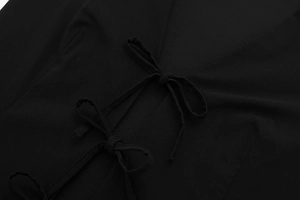 Détail du haut élastique noir avec double nœud papillon et texture de tissu en maille