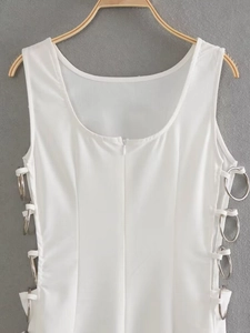 Detail view of the silver metal ring side cutouts on a white sleeveless dress