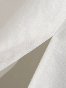 Close-up of side slit design and woven fabric texture on a white summer dress