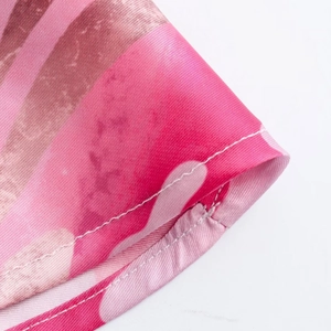 Detailed close-up of pink and brown striped fabric with white stitching on a midi skirt