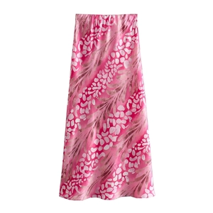 Detail of a shiny pink leopard print satin midi skirt with high-gloss fabric texture
