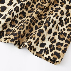 Dettaglio del tessuto dell'abito con stampa leopardata, motivo animalier e cuciture orlo