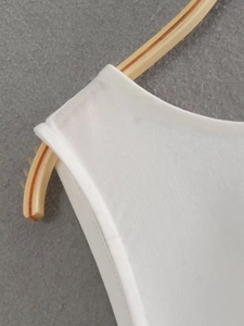 Close-up of white breathable linen blend fabric with neat stitching on a slim dress
