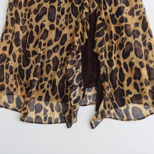 Détail de l'ourlet de robe à imprimé léopard avec volants et doublure marron foncé