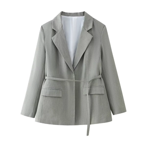 Close-up of light gray belted blazer with refined texture and classic flap pockets