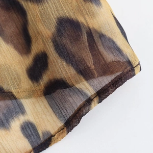 Détail du tissu en maille transparente à imprimé léopard avec couture d'ourlet