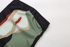 Detail of the elastic waistband and abstract plant print on the black knit dress
