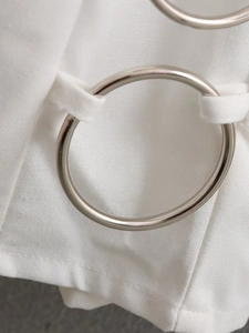 Detailed close-up of the silver metal ring accent on a white slim-fit summer dress
