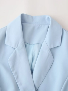 Détail d'une robe blazer bleu clair avec revers classique et finitions de couture