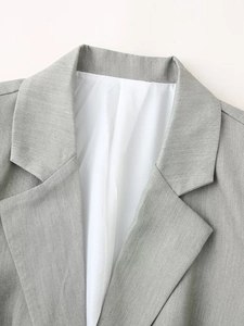 Detail of the notched lapel and white lining on a textured grey woven blazer jacket