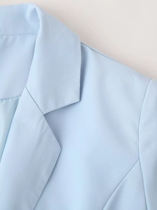 Détail de la robe blazer plissée bleu clair montrant le revers et la couture d'épaule