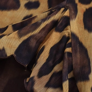 Gros plan sur une robe en mousseline à imprimé léopard avec volants et plis détaillés