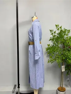 Detail of blue striped shirt dress featuring a brown woven belt and rolled-up button sleeves