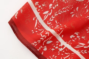Gros plan détaillé du tissu à imprimé floral rouge avec des feuilles dorées