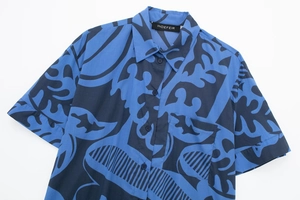 Detail of short-sleeve shirt with blue abstract floral print, collar, and chest pocket