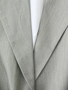 Detail of grey blazer notch lapel showing twill texture and linen-blend fabric quality