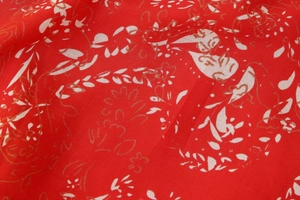 Vue détaillée du tissu à imprimé cachemire rouge avec des contours dorés texturés