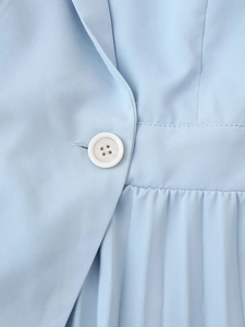 Vue détaillée de la robe blazer bleu clair montrant le col à revers et la jupe plissée