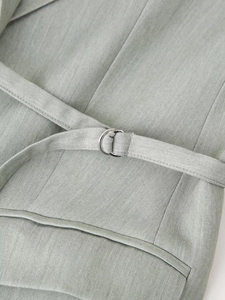 Detailed view of sage green textured fabric with adjustable D-ring metal buckle belt