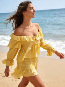 Detail of yellow off-shoulder chiffon top with ruffle sleeves and matching mini skirt