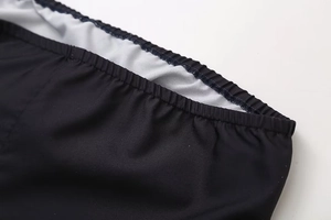 Detailed macro view of the elastic waistband and fine stitching on a black printed dress